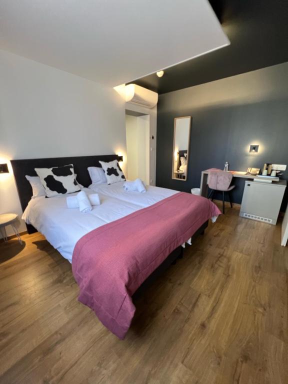 比桑Hôtel Restaurant & Spa du Tremplin的一间卧室配有一张大床,床上铺有紫色毯子