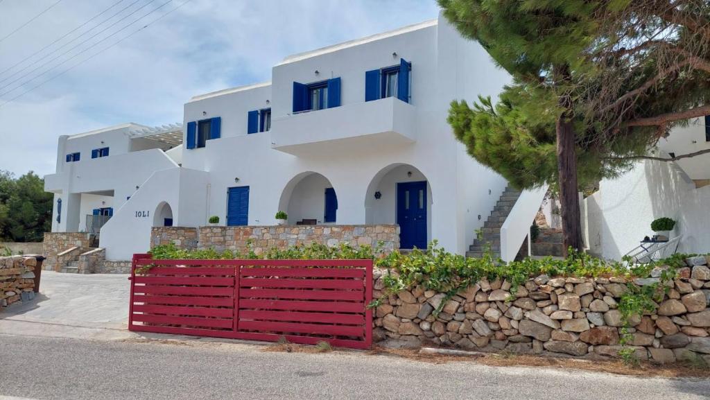 AloproniaIoli Apartments的一座带蓝色窗户和红色门的房子