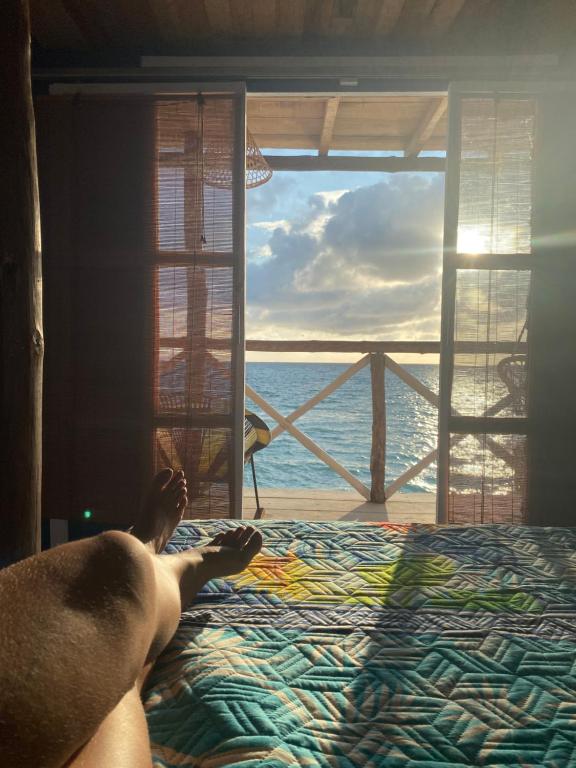 巴尔Tequila SunBeach Baru Eco-Hotel的躺在床上看海洋的人
