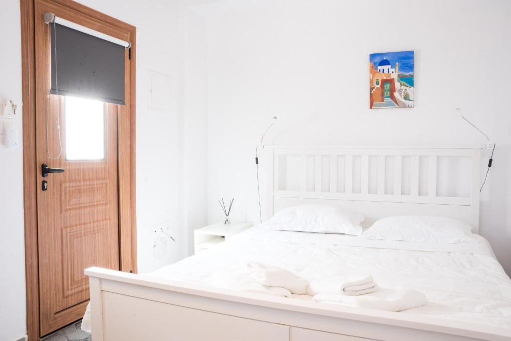 费拉Fira Central Budget Room and Kitchen的白色的卧室设有白色的床和门