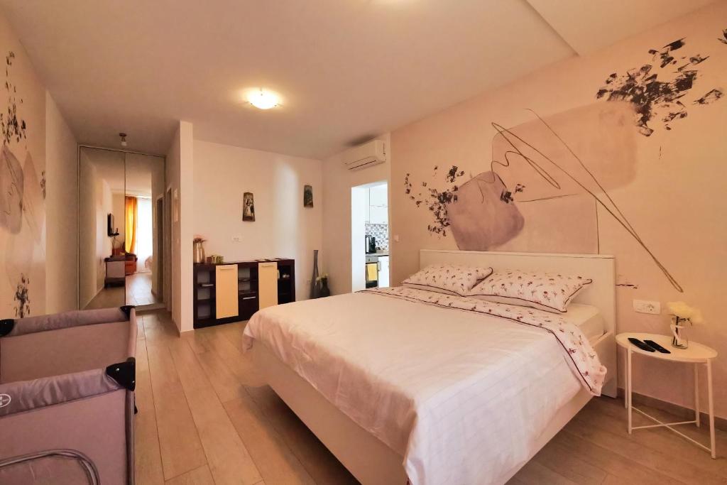 MočićiDubrovnik Airport Apartment Pascal的卧室配有一张白色大床,墙上挂有绘画作品