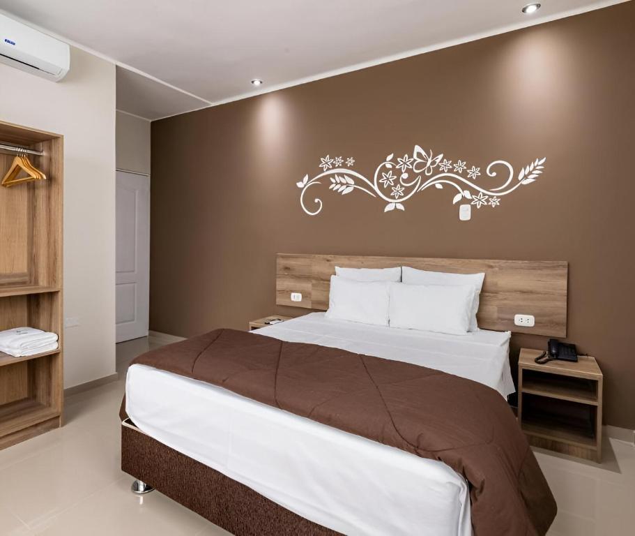 皮乌拉Hotel Solec Piura的一间卧室设有一张大床和墙壁