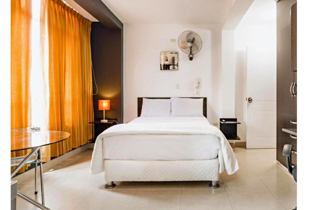齐克拉约ESCALA BUSINESS HOTEL的卧室配有白色的床和桌子
