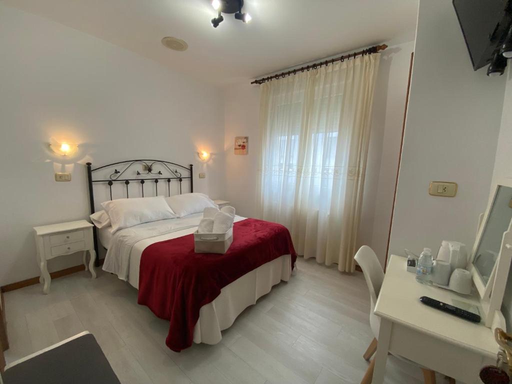巴约讷Hotel Carabela La Pinta的一间卧室配有一张带红色毯子的床和一张书桌