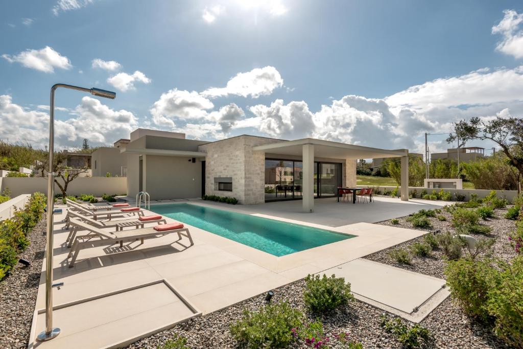 MódhionDeux Olives Luxurious & Quality Villa的一个带游泳池和房子的后院