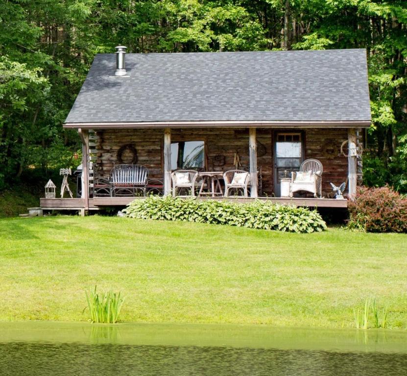 Great ValleyCozy Cottage on Pond的小木屋设有门廊,配有桌椅