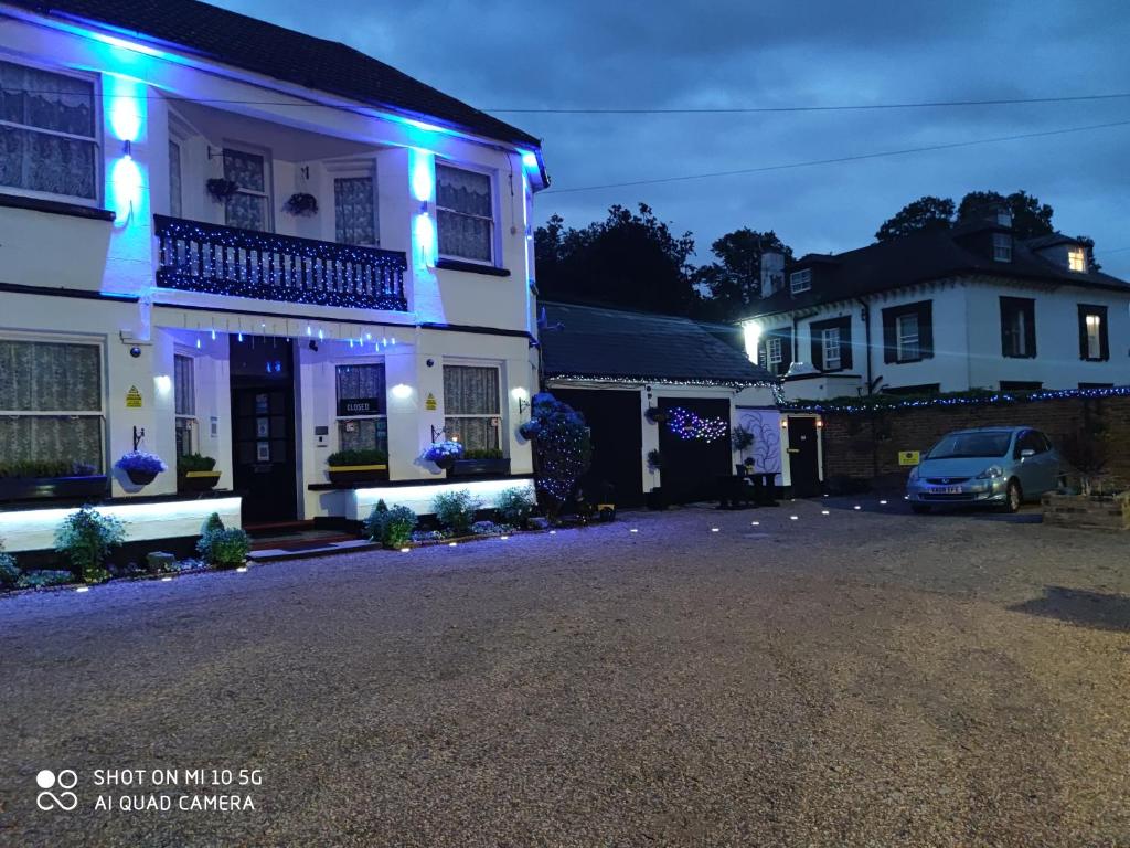 斯劳Sussex Lodge Guest House的白色的房子,上面有蓝色的灯光