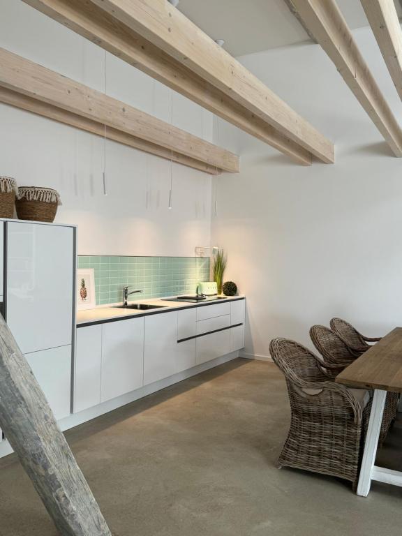 维岑多夫Sievershof Poolloft的厨房配有白色橱柜和桌椅