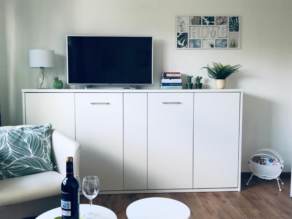 维勒斯威特Eifel-House - FeWo的客厅配有白色橱柜和电视机