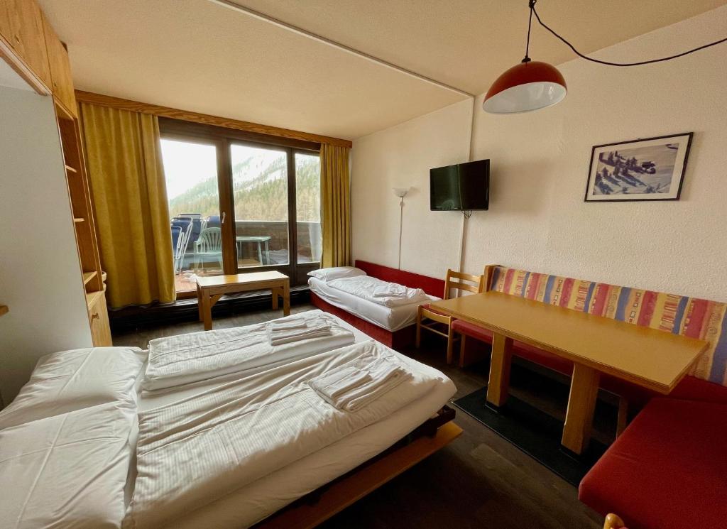 马索科托Maso Corto Alpine Adventure的一间卧室配有一张床、一张桌子和一张沙发