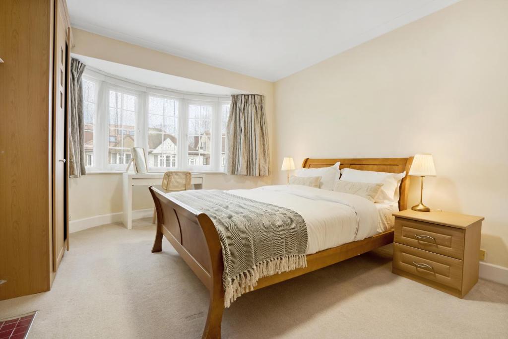 芬奇利5 bed with parking and large private garden的一间卧室设有一张大床和一个窗户。