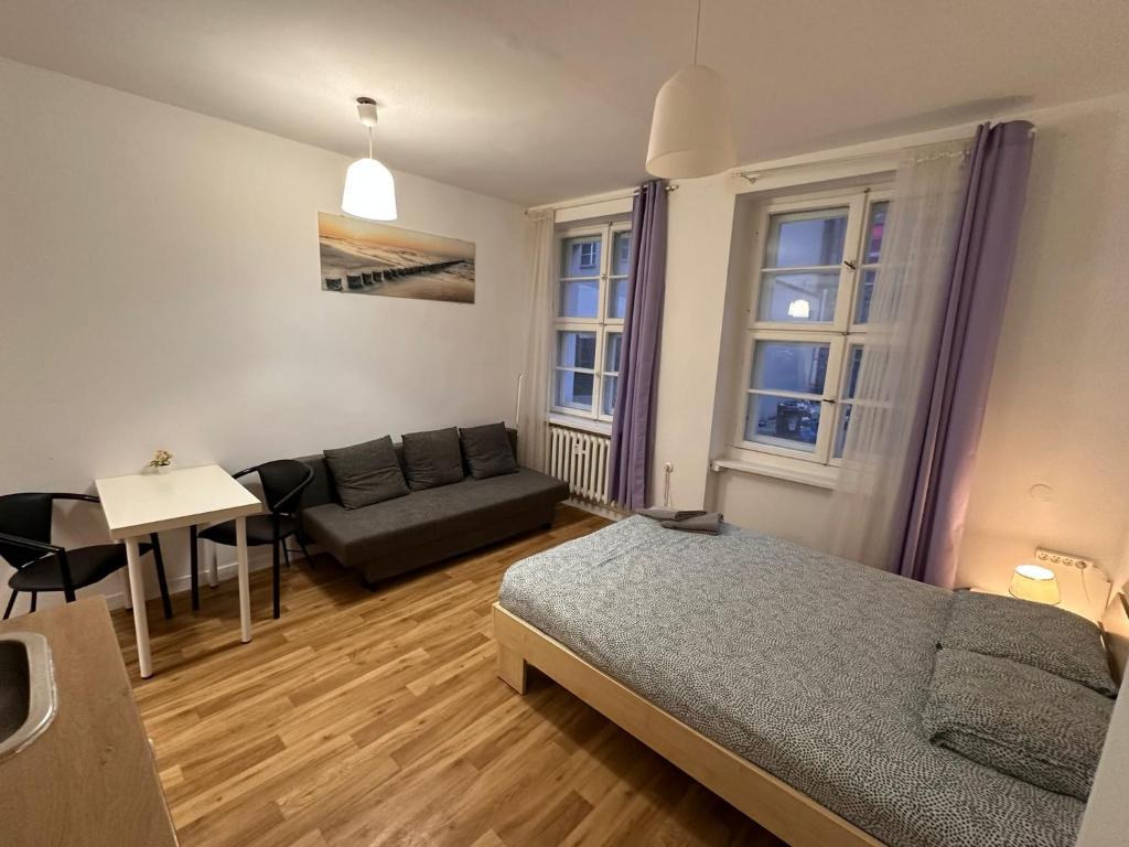 波兹南Kozia 24/25的一间卧室配有一张床、一张沙发和一张桌子