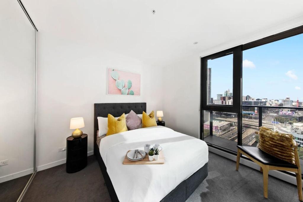 墨尔本A Modern & Spacious 2BR Apt City Views Southbank的一间卧室设有一张床和一个大窗户