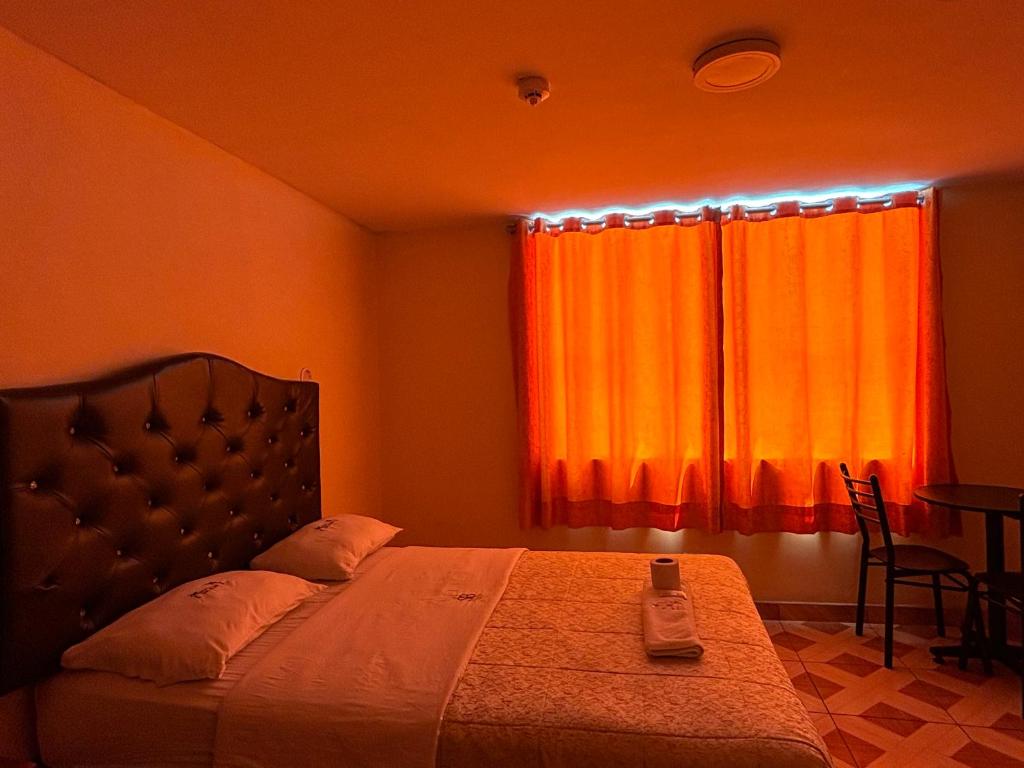 利马Hospedaje San Blas的一间卧室配有一张带橙色窗帘的床