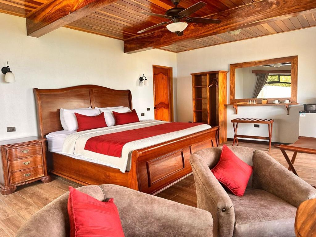 蒙泰韦尔德哥斯达黎加Hotel Trópico Monteverde的一间卧室配有一张床和两把椅子