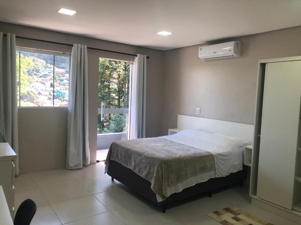 格拉玛多Vista da Serra.的一间卧室设有一张床和一个窗口