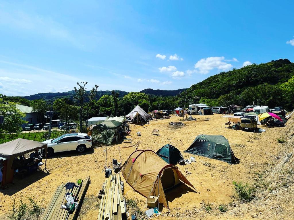 四万十市雅玛米苏度假屋的一群帐篷和汽车在田野里