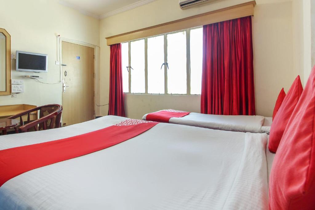 AmeerpetOYO Luxury Villas Near Begumpet Airport的一间卧室配有一张带红色窗帘的大床