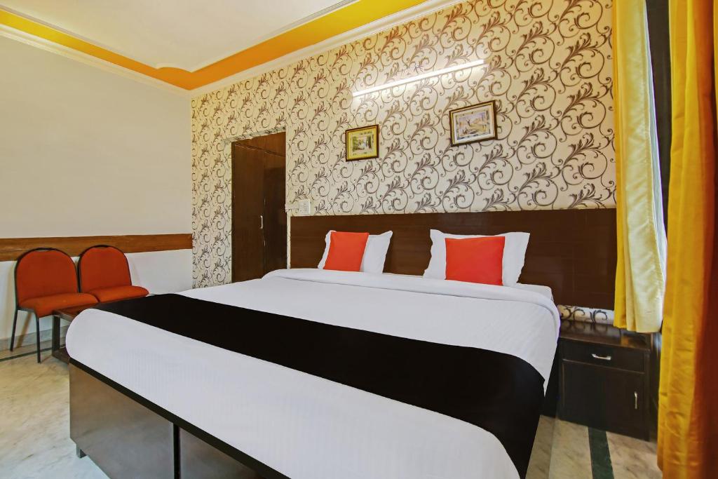 古尔冈Super Capital O Tipsyy 006 Near Aravali Biodiversity Park的一间卧室配有一张带红色枕头的大床