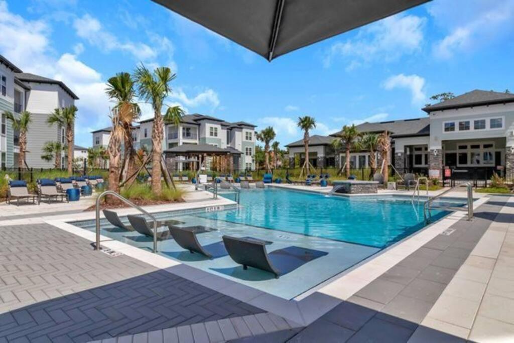 杰克逊维尔BeautifulApartmentNeartheAirport&RiverCity的棕榈树和别墅度假村的游泳池