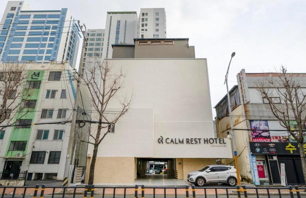 釜山Gwanganli Calm Rest Hotel的停在大楼旁的商场前的汽车