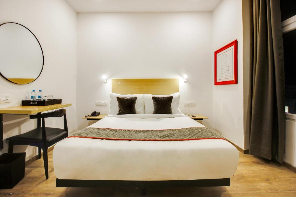 库卡特帕尔莱Townhouse Rcc Prime的一间卧室配有一张床和一张带镜子的书桌