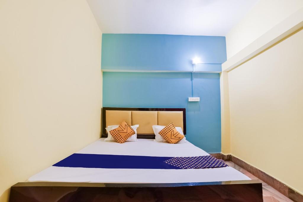 BankipurSPOT ON Luv-kush Inn的蓝色墙壁间的一张床位
