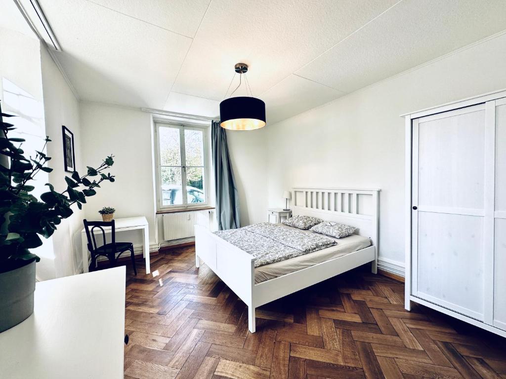 DerendingenBusiness Apartment in Derendingen的白色卧室配有床和桌子
