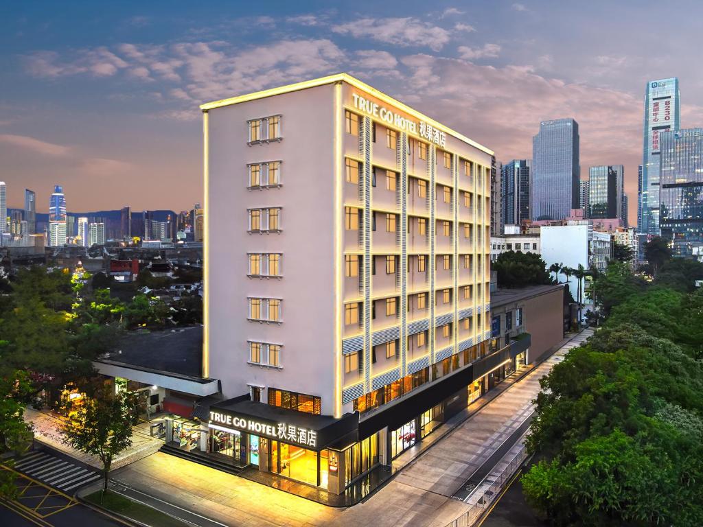 深圳深圳福田华强北秋果酒店的一座高大的白色建筑,以城市为背景