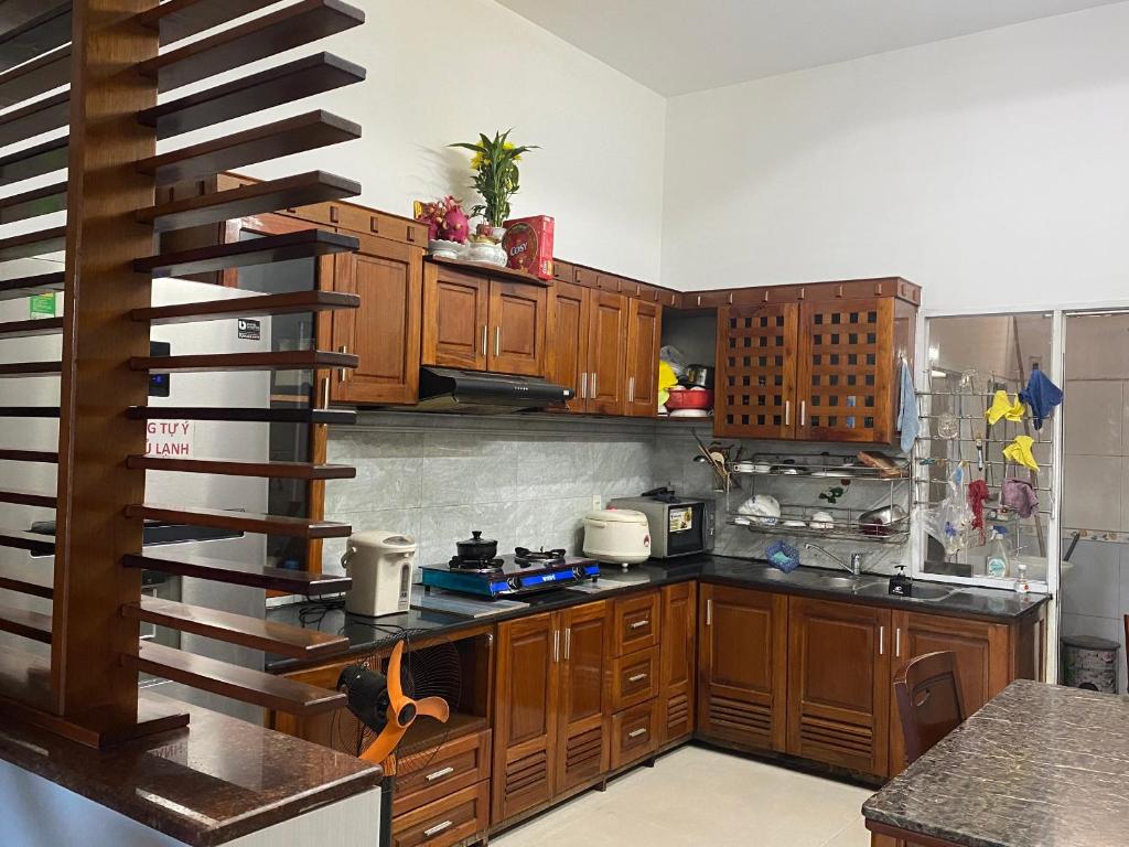 岘港CÁT TƯỜNG MOTEL的一间带木制橱柜和螺旋楼梯的厨房