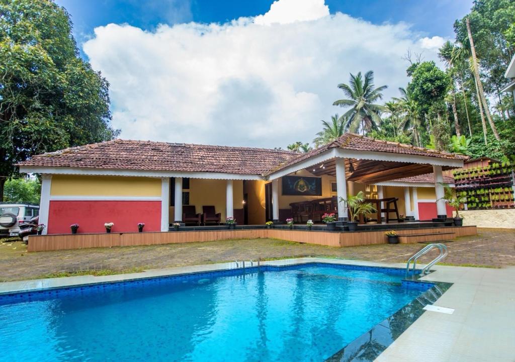 VaduvanchalChandragiri Wayanad Traditional Bungalow by VOYE HOMES的别墅前设有游泳池