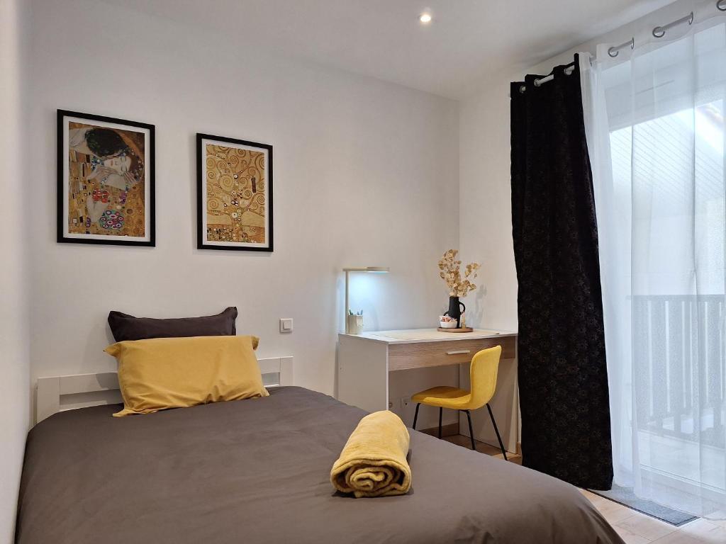 阿让Chambre GUSTAV的一间卧室配有一张床、一张书桌和一个窗户。