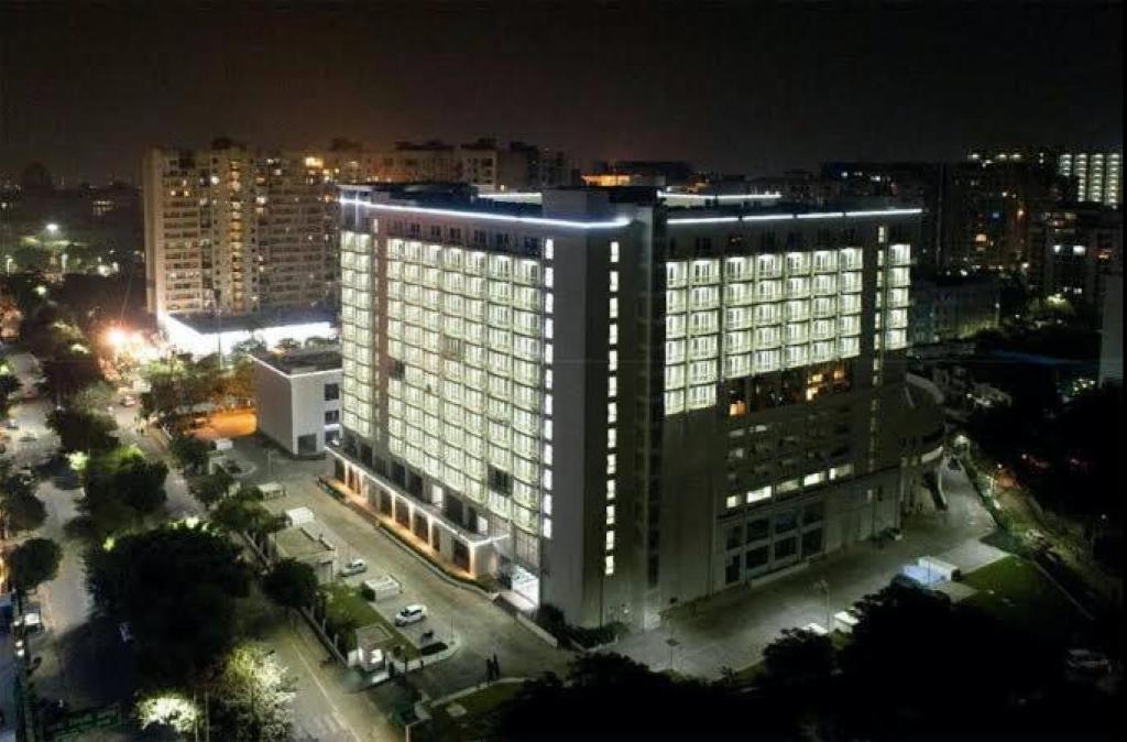 勒克瑙Country Inn & Suites Lucknow Gomti Nagar的一座大建筑,上面有灯,晚上