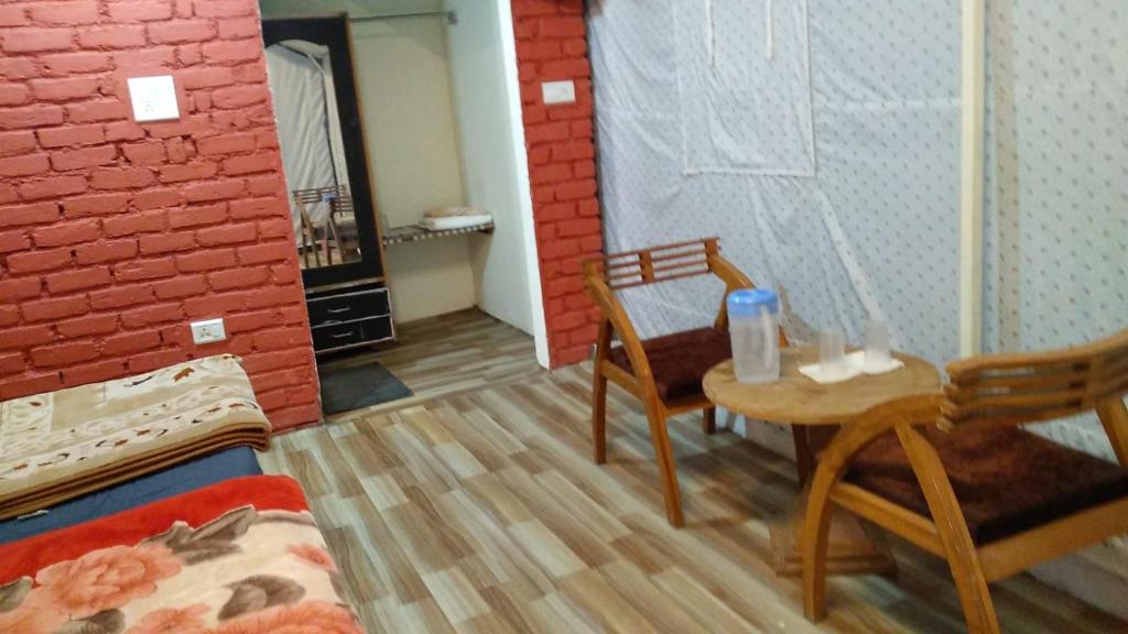 穆索里Kandi Orchard Resort的一间房间,配有两把椅子和一张桌子