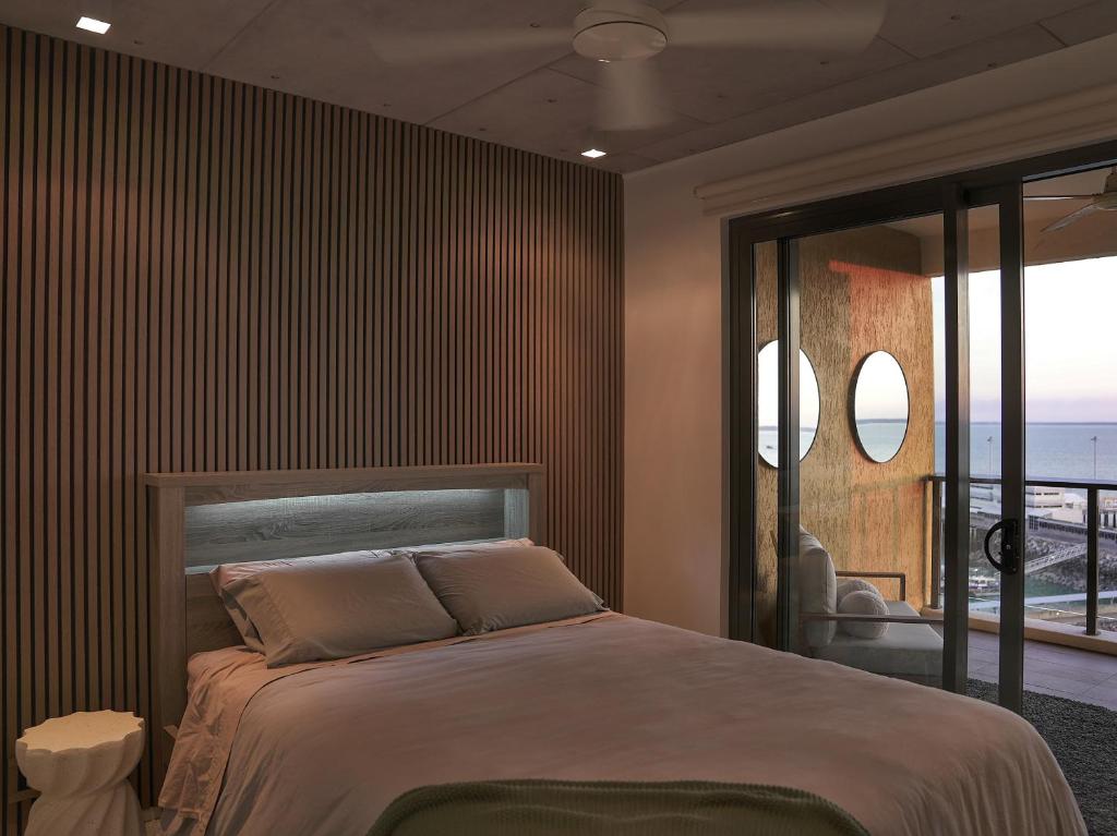 达尔文Penthouse-level Waterfront Apartment的一间卧室设有一张床,享有海景