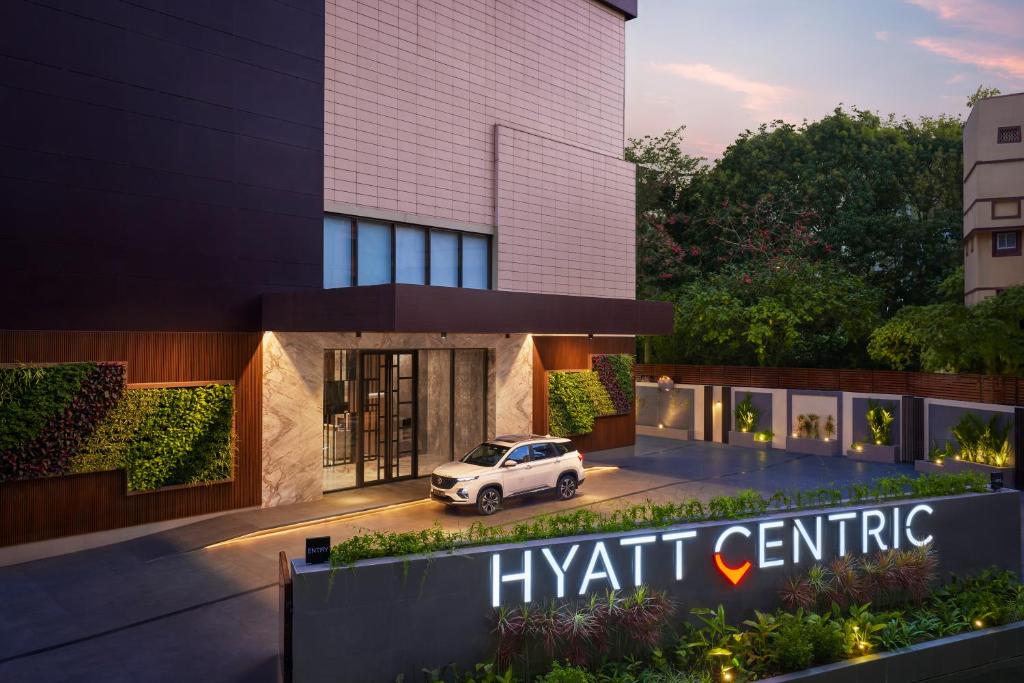 加尔各答Hyatt Centric Ballygunge Kolkata的一座中央建筑的 ⁇ 染,外面有一辆汽车