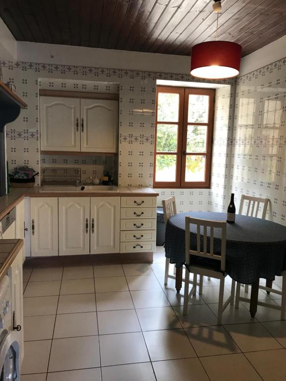 贝尔韦villa Marguerite terrasse & garage的厨房配有白色橱柜和桌椅