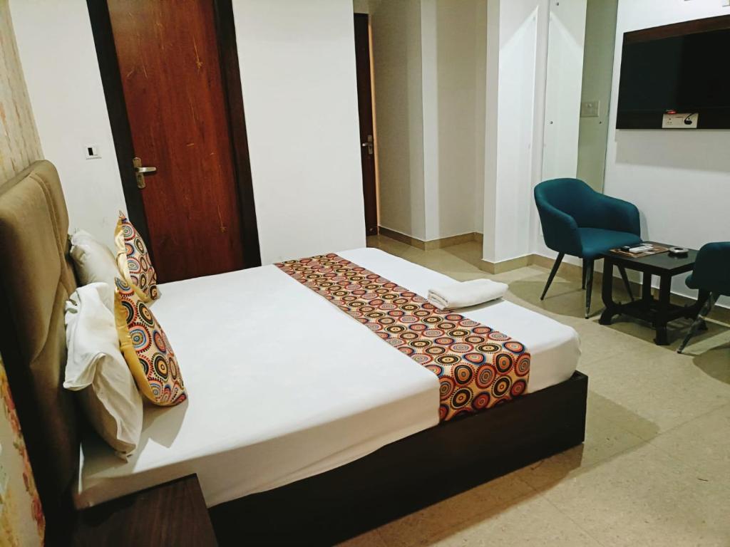 新德里Airport Hotel IVY的配有一张床和一把椅子的酒店客房