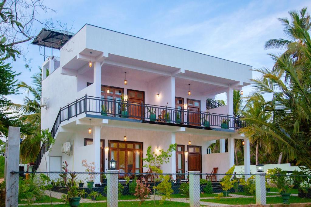 蒂瑟默哈拉默My Resort Yala的带阳台和棕榈树的白色房屋
