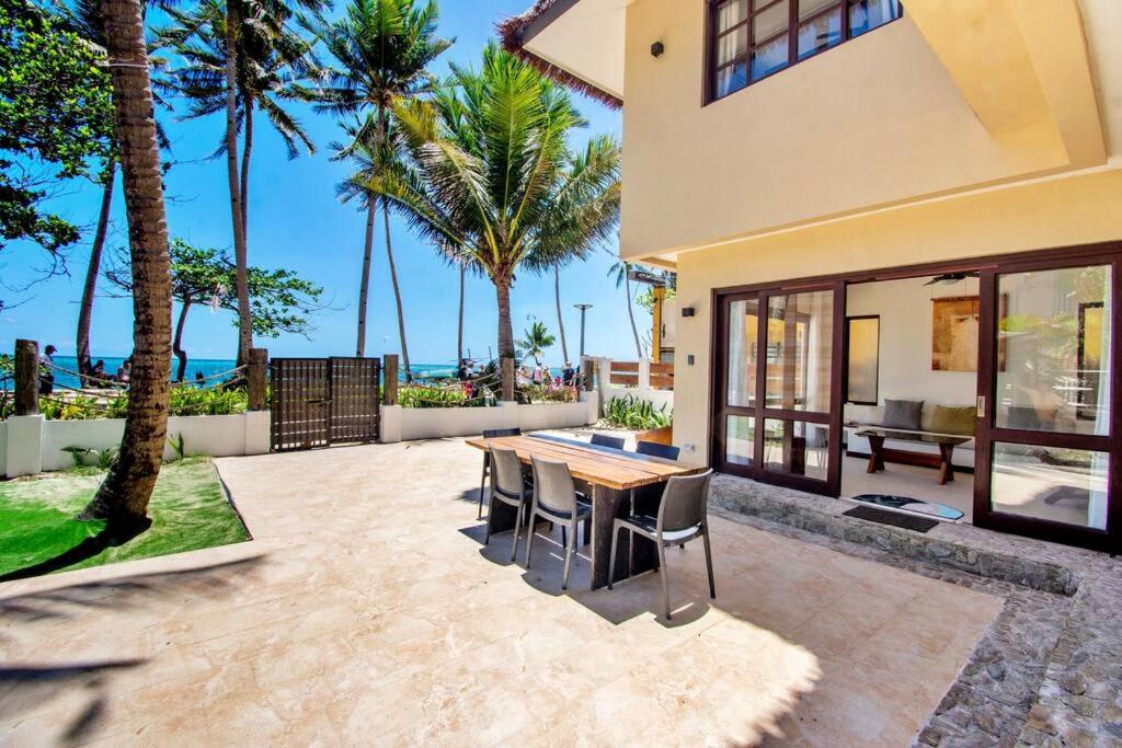 长滩岛Hey Jude Bulabog Beachfront Residence的房屋设有带桌椅的庭院