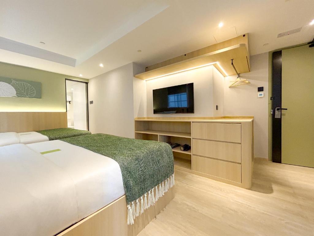香港Urbanwood Hung Hom的一间卧室配有一张床和一台平面电视
