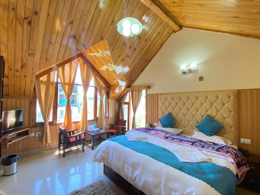 马拉里Himalayan Ecstacy的一间带一张大床的卧室,位于一个拥有木制天花板的房间