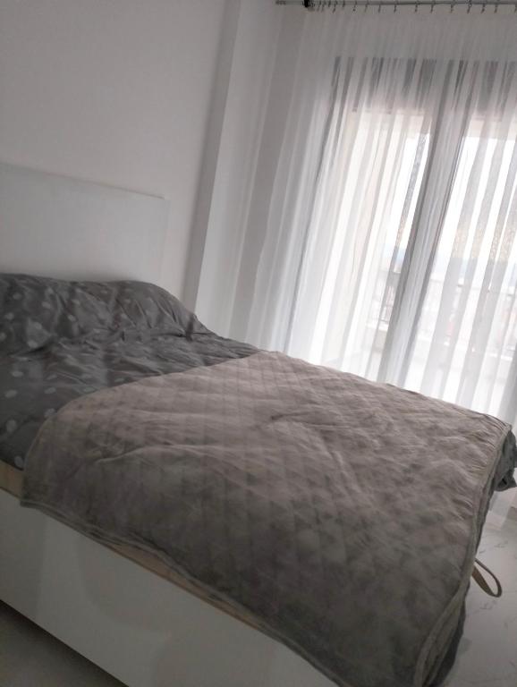 蒂瓦特Tivat Apartman的窗户客房内的一张床位