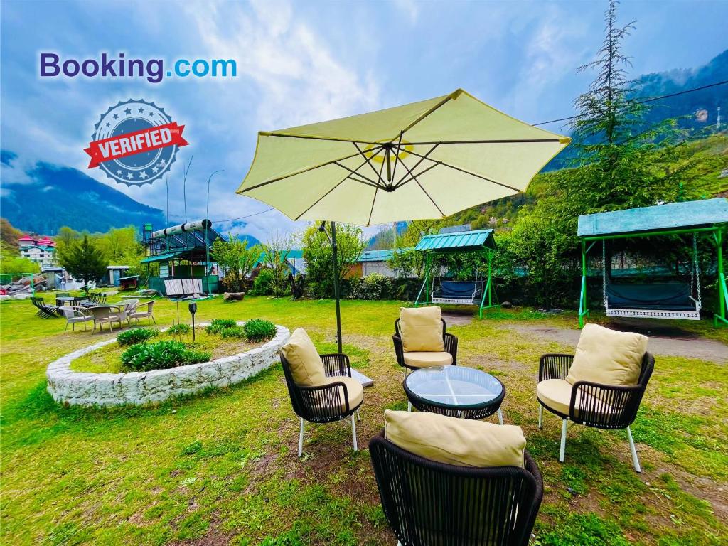 马拉里Himalayan Nature Walk Resort, Manali的一组椅子和一张桌子及一把伞