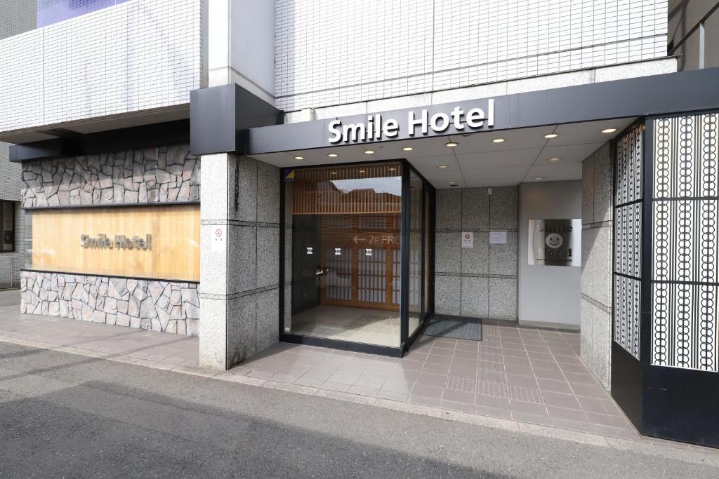 京都Smile Hotel Kyoto Karasuma Gojo的一座带微笑的酒店标志的建筑