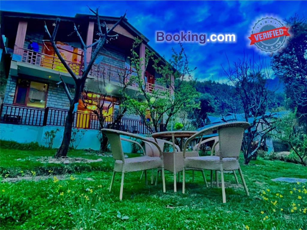 马拉里4 Bedroom Luxury Bungalow in Manali with Beautiful Scenic Mountain & Orchard View的坐在房子前面的草上一组椅子