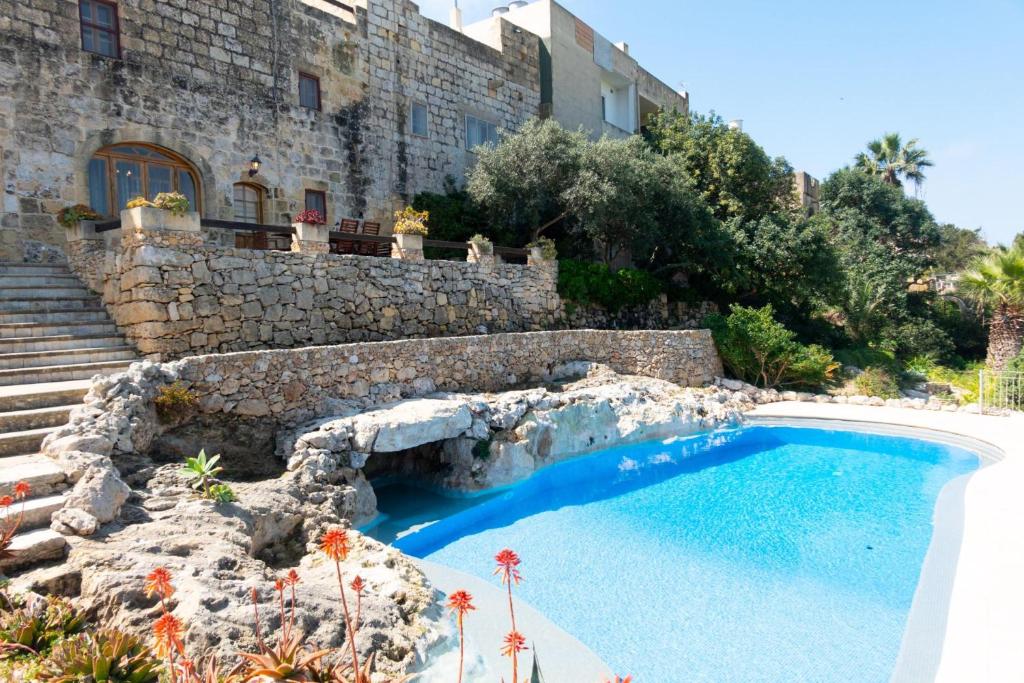 MunxarVilleleynah Amazing Gozitan Villa Pool - Happy Rentals的大楼前的游泳池