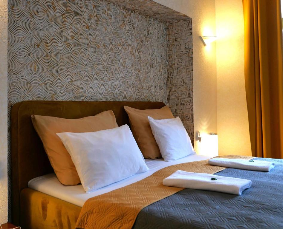 利贝雷茨拉德尼斯酒店的一张带两个白色枕头和两个文件夹的床