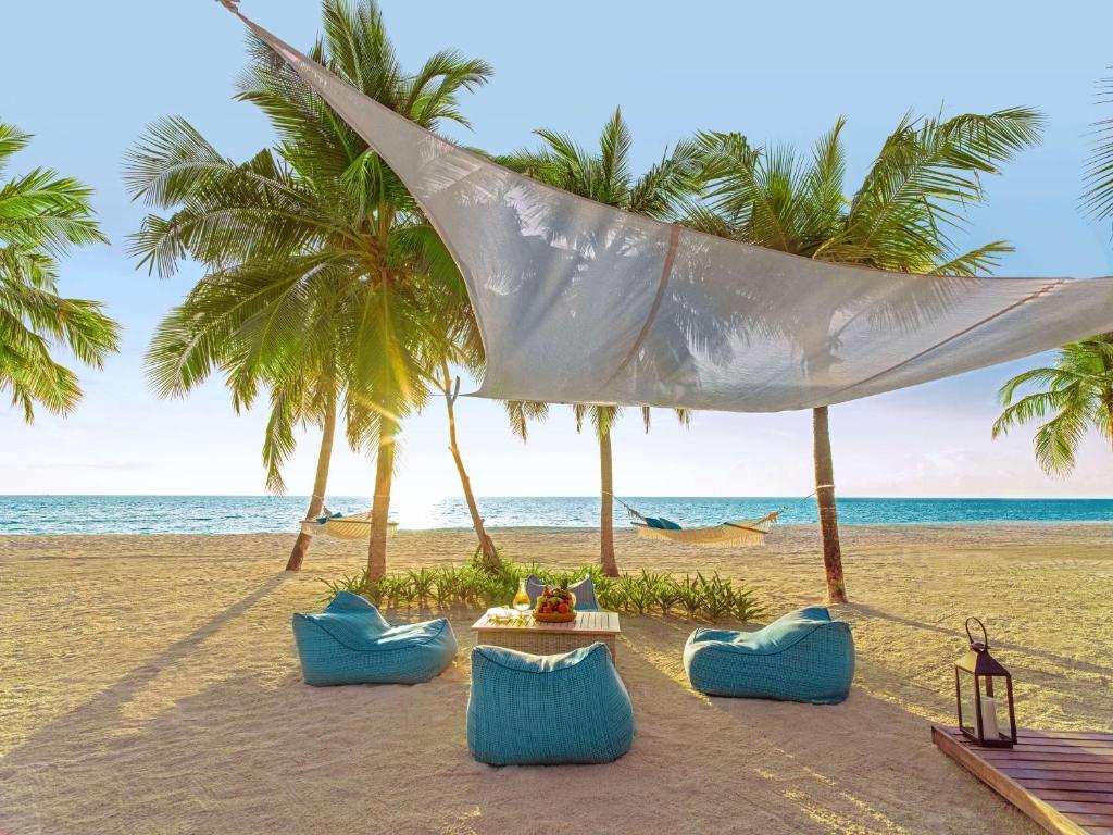 Reethi Rah瑞迪雷唯一的一个带椅子和桌子的海滩和棕榈树