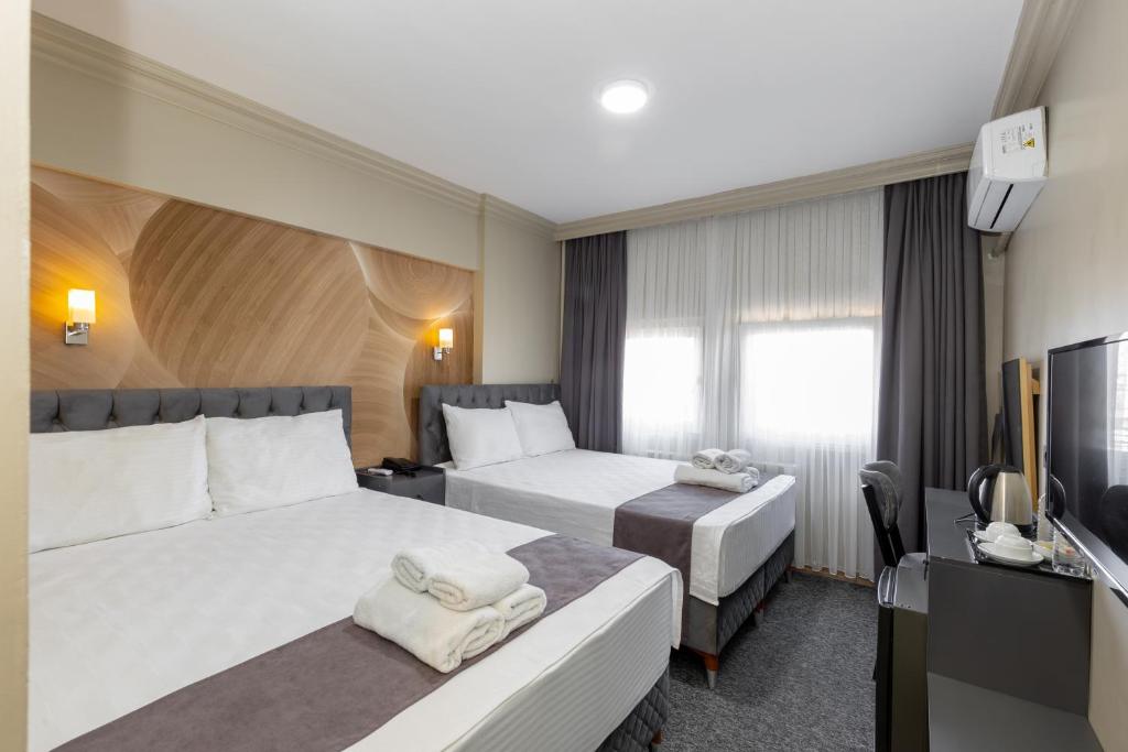 伯萨Loyal City The Best Hotel in Bursa的酒店客房设有两张床和电视。